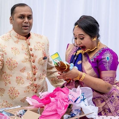 couple excited to unwrap baby krishna plush toy