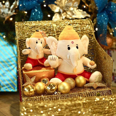 ganesh plushes sitting on gold chair